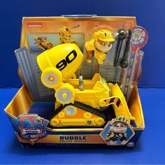 an action figure in a toy box with other toys around it on a blue background