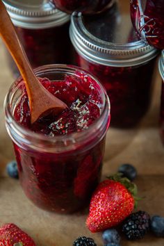 berries and jam in jars with a wooden spoon