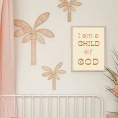 a baby's room with pink and white decor, crib bedding, and wall hangings