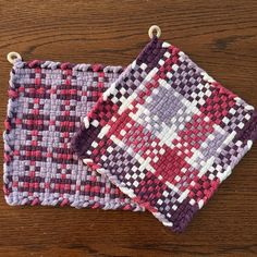 two pieces of woven fabric sitting on top of a wooden table