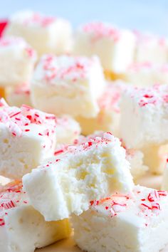 several pieces of white cake with red and white sprinkles on top, sitting on a plate