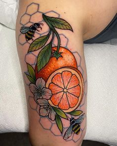 an orange with leaves and flowers on the thigh