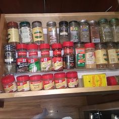 a wooden shelf filled with lots of different types of spices and seasonings on top of it