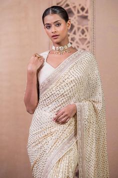 Ivory, gold georgette saree is uplifted with mukaish work and accentuated with a hand-embroidered border. Paired with a textured blouse in chanderi with embroidered sleeves.
Components: 2
Pattern: Embroidered
Type Of Work: Mukaish
Neckline: Sweetheart
Sleeve Type: Half
Fabric: Saree : Georgette, Blouse : Chanderi
Color: Ivory,Gold
Other Details: 
Tassel sleeves
Back cutout
Occasion: Wedding,Bride - Aza Fashions Elegant White Pre-draped Saree With Pallu, White Pre-draped Saree With Gota Work For Navratri, Festive Cream Georgette Pre-draped Saree, Elegant Georgette Saree With Gota Work, Gold Georgette Pre-draped Saree For Navratri, Elegant Wedding Pre-draped Saree With Gota Work, Gold Georgette Blouse Piece With Mirror Work, Elegant Georgette Blouse With Gota Work, Gold Georgette Blouse Piece With Dupatta