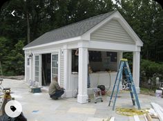 a man working on a small white shed