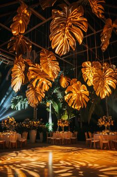 a large room filled with lots of tables covered in gold cloths and hanging lights