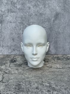 a white mannequin's head sitting on top of a gray countertop