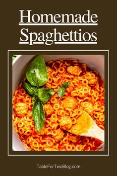 a bowl filled with pasta and meat next to a wooden spoon on top of it