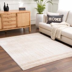 a living room with a white couch and rug