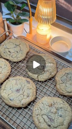 chocolate chip cookies cooling on a wire rack next to a lamp and teapots