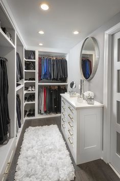 a walk - in closet with white carpet and shelves filled with clothes on hangers