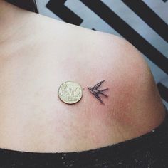 a small tattoo on the back of a woman's shoulder