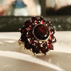 Vintage 9ct gold multi-stone garnet flower cluster ring. Comprising a large round-mixed-cut garnet in the centre, surrounded by 2 rows of smaller garnets, forming a flower fully-blossomed. This substantial ring made of solid gold material, each stone individually claw-set, well-presented and intact condition all round. Luxury Classic Garnet Diamond Ring, Luxury Garnet Jewelry With Intricate Design, Heirloom Style Garnet Cluster Ring, Heirloom Style Round Garnet Cluster Ring, Heirloom Garnet Cluster Ring, Round Multi-stone Ruby Ring With Garnet, Vintage Round Garnet Cluster Ring, Gold Garnet Ring, Flower Cluster Ring