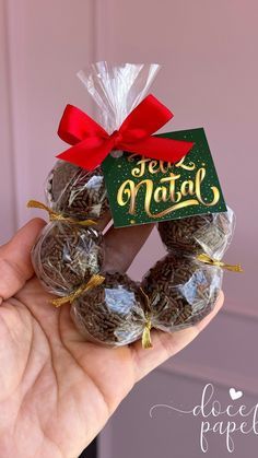 a hand holding a small wreath made out of chocolates