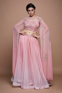 Pastel pink net gathered lehenga with sequins and beaded hand embroidered waistband. Comes with a padded blouse with cape sleeves.
Components: 2
Pattern: Hand embroidered
Type Of Work: Sequins, Beads
Neckline: Round
Sleeve Type: Cape Sleeves
Fabric: Net, Lining : Crepe
Color: Pink
Other Details: 
Attached lining
Lehenga length : 43 inches
Approx Product Weight : 1.5 - 2.5 Kgs
Closure :
Lehenga : Side zip
Blouse : Back hooks
Occasion: Destination Wedding - Aza Fashions Blouse With Cape, Gathered Lehenga, Lehenga Images, Hand Embroidered Blouse, Lehenga Pattern, Padded Blouse, Fashion Sewing Tutorials, Lehenga Blouse, Beaded Neckline