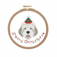 a white dog with a santa hat on it's head in a cross stitch hoop