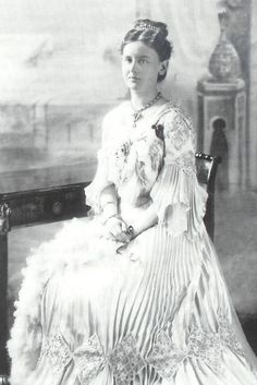 an old black and white photo of a woman in a dress