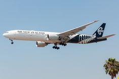 an air new zealand plane flying in the sky with its landing gear down and it's wheels out