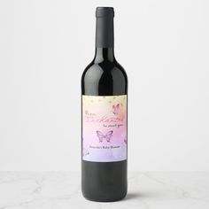 a bottle of red wine with a butterfly label on the front and bottom, sitting on a marble surface