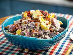 a blue bowl filled with food sitting on top of a table