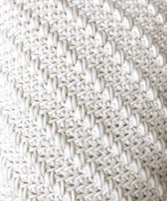 the texture of a white knitted blanket is shown in this close up photo, which appears to be very soft