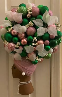 a mannequin's head is adorned with green, pink and white ornaments