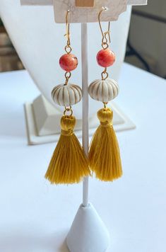 Fall in love with these pumpkin earrings with golden silky tassels, cream with gold accent miniature pumpkins and orange apple coral beads. Gold-plated, nickel-free ear wires. 3.5" drop. Orange Tassel Dangle Earrings, Adjustable Orange Tassel Earrings, Orange Beaded Tassel Earrings As Gift, Orange Tassel Earrings, Elegant Orange Tassel Earrings For Gift, Orange Tassel Drop Earrings With Dangling Beads, Orange Apple, Pumpkin Earrings, Coral Beads