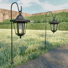 two old fashioned street lamps in the grass