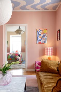 a living room filled with furniture and pink walls