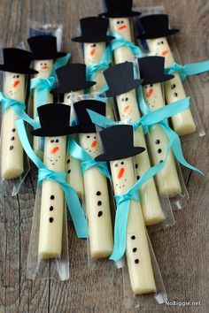 snowmen are made out of marshmallows with blue ribbon and black hats on them