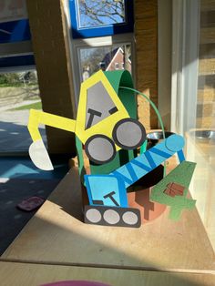 an origami robot made out of construction paper sitting on top of a table