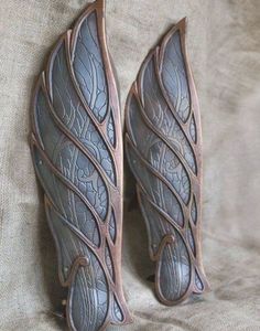 two metal wall hangings with leaves on them