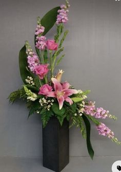 a vase filled with pink flowers and greenery