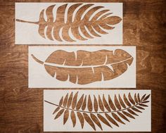 three cut outs of leaves on a wooden surface