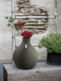 two vases with flowers in them sitting on a table