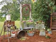 the garden is full of potted plants and gardening tools, including an old wheel