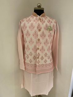 This is a Readymade Raw Silk Kurta set in Pink.This Collar Neck and Full Sleeve attire is Allured with Buttons, Resham and Sequins Work all over jacket.on collar elegant heavy embroidery is done.Available with a Peach raw Silk Churidar. Colour options available. Customisation available. Traditional Naqshi Kurta For Reception, Traditional Wear With Naqshi For Diwali Reception, Traditional Bandhgala For Reception During Diwali, Traditional Nehru Jacket With Naqshi, Reception Kurta In Raw Silk With Dabka Detailing, Traditional Raw Silk Nehru Jacket With Naqshi, Traditional Raw Silk Kurta For Reception, Traditional Nehru Jacket In Raw Silk With Naqshi Detailing, Raw Silk Kurta With Dabka For Reception