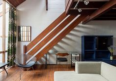 a living room filled with furniture next to a wooden floor covered in white walls and windows