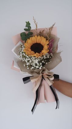 a bouquet of sunflowers and baby's breath is tied to the wall