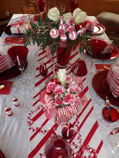 the table is set with candy canes and roses