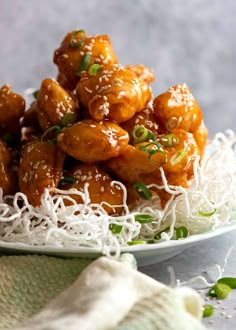 a white plate topped with chicken covered in sesame seeds