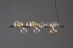 a bunch of lights that are hanging from a light fixture in a room with gray walls