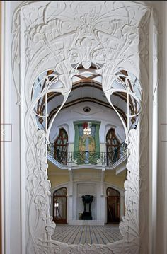 the inside of a large building with an ornately decorated doorway and balcony above it