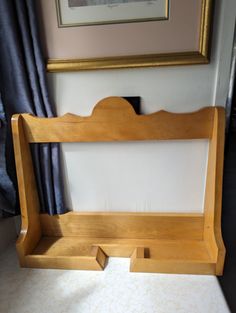 a wooden bed frame sitting on top of a floor next to a window with curtains