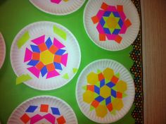 paper plates with colorful designs on them sitting on top of a green tableclothed surface