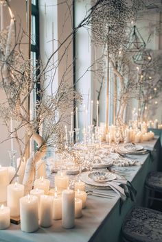 the table is set with candles and branches