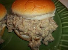 two hamburgers with meat and cheese on a green plate, ready to be eaten