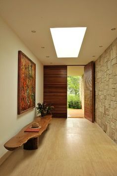 a wooden bench sitting in the middle of a hallway next to a wall with paintings on it