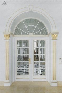 an empty room with two white doors and gold trim on the front door, along with marble flooring