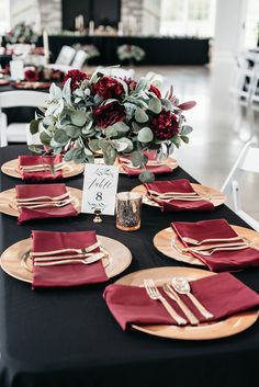 the table is set with red and gold place settings